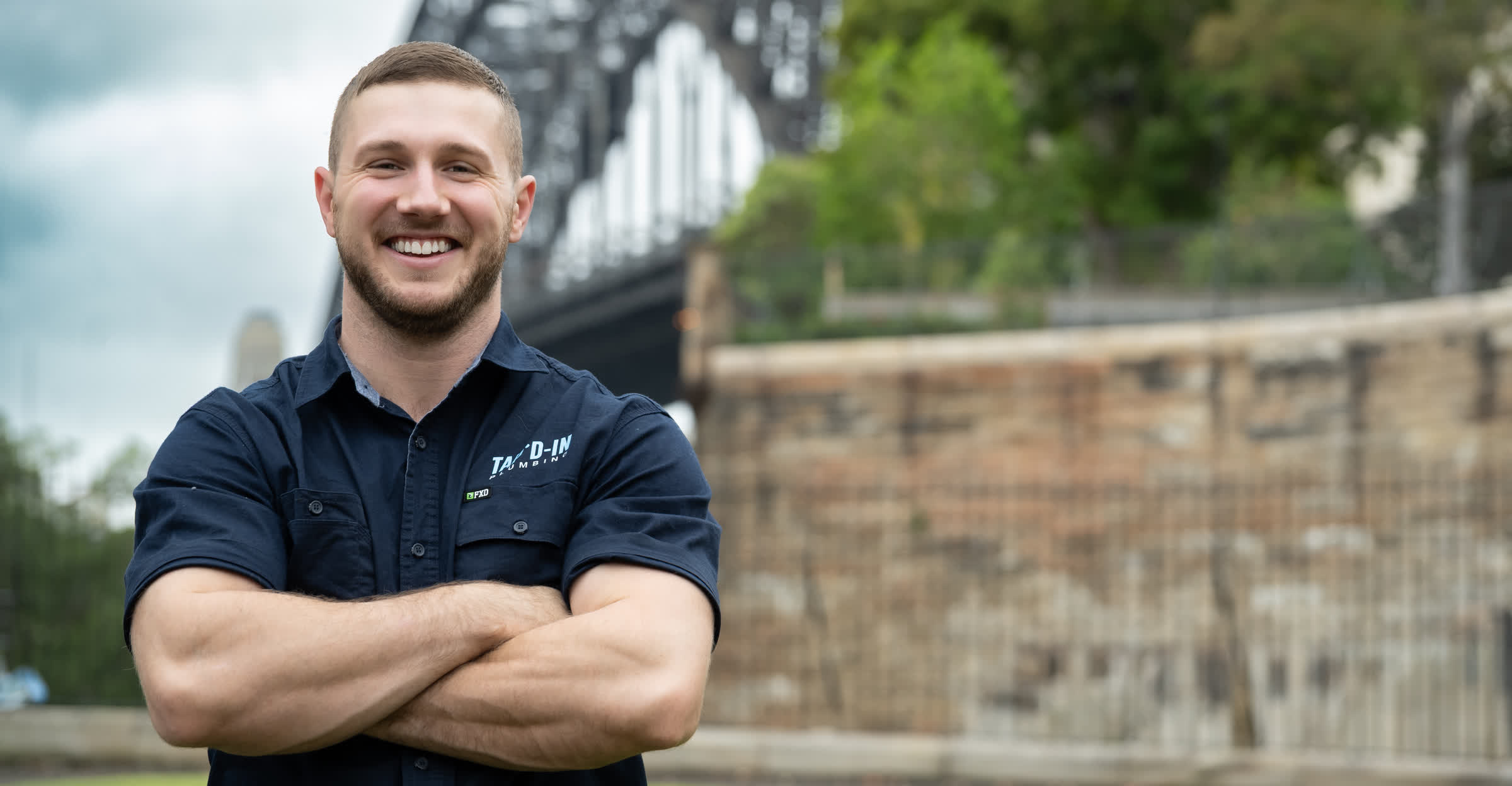 Jayden McDonald, licensed plumber Castle Hill, standing outdoors in branded work shirt